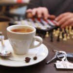Cup of coffee and chess on the desk