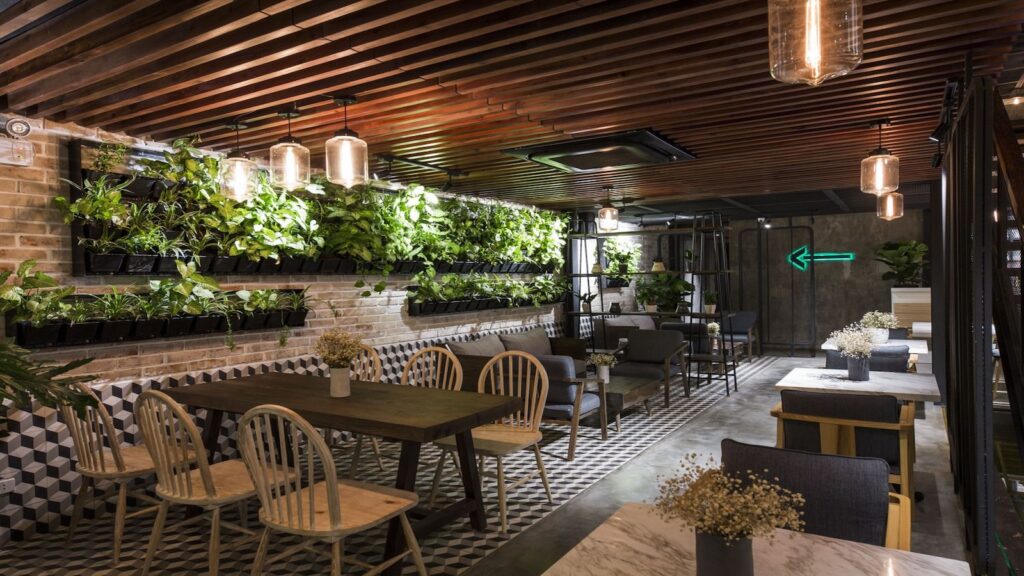 The interior of a restaurant with plants on the walls.
