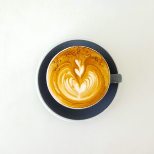 top view of coffee with foam art in the shape of heart and semi circle, cafe with healthy snacks