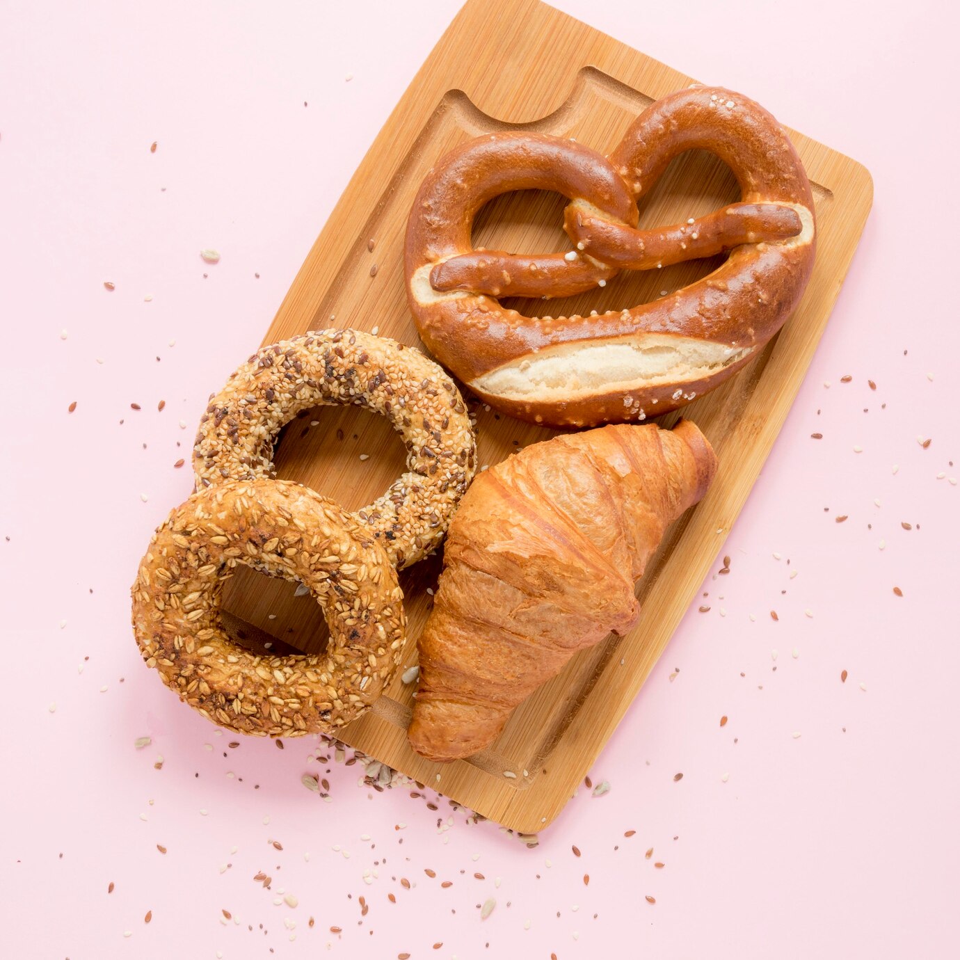 wooden board with baked snacks of donut, pretzel, croissant in a cafe with healthy snacks