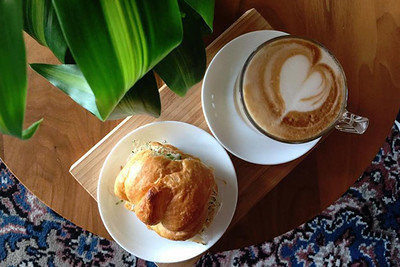 coffee and a vegan baked good side by side on plates. both from our sustainable coffee shop, in toronto