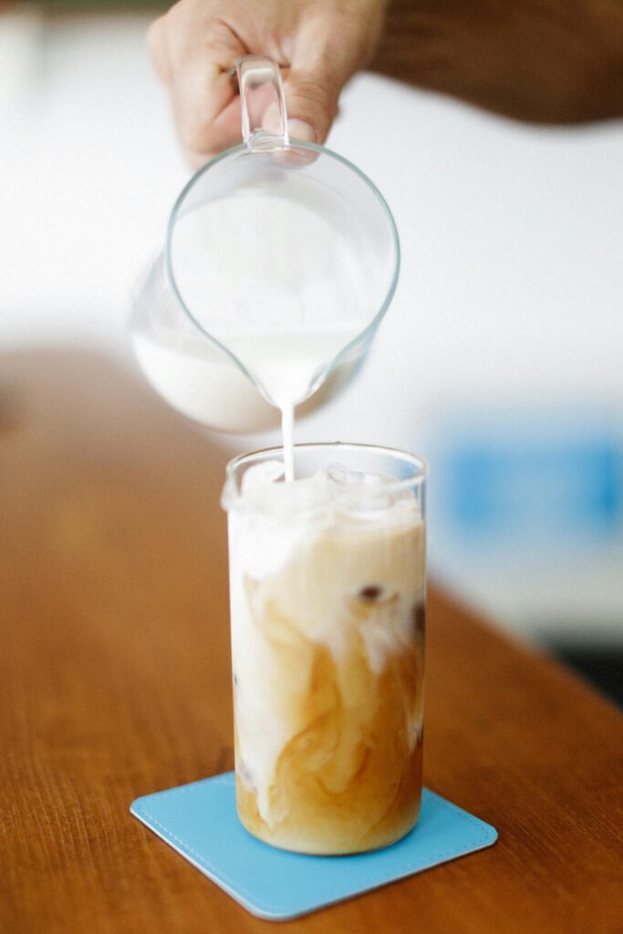 milk pored in the glass of cold brew