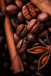 Roasted coffee beans with cinnamon sticks and star anise, showing the rich flavors of Premium Herbal Coffee at PSB Café.